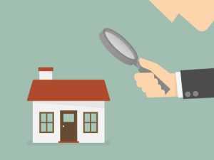 Man holding magnifying glass to home