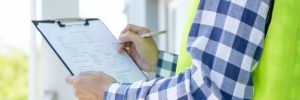 inspector or engineer is inspecting construction and quality assurance new house using a checklist. Engineers or architects or contactor work to build the house before handing it over to the homeowner